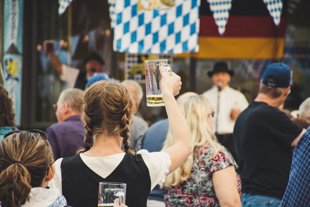 junge Frau hebt Bierkrug Tipps für das Oktoberfest in München